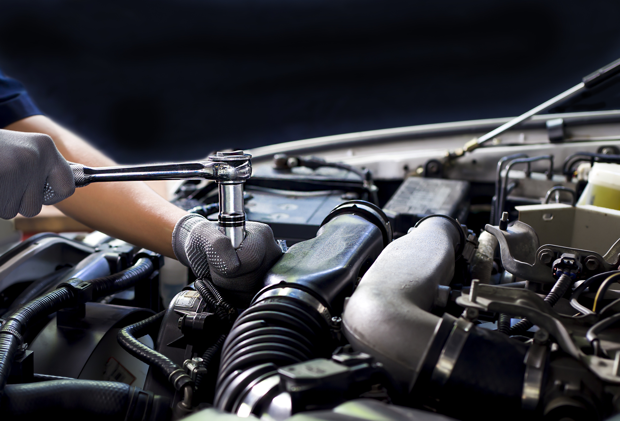Car mechanic working on car engine, car maintenance concept.